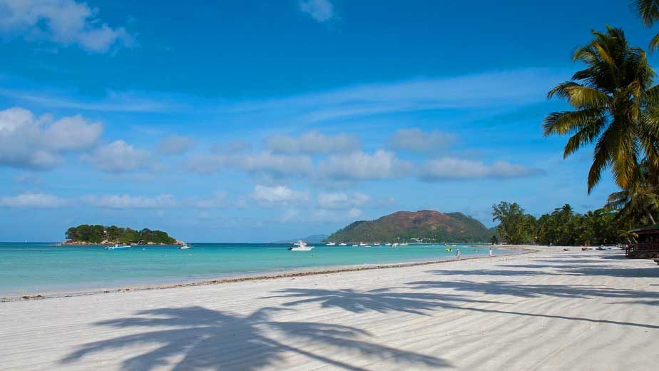 Długa spokojna plaża Côte d'Or z łodziami i turkusową wodą, Praslin